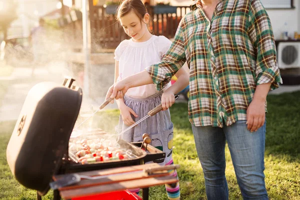 Vrouw Grillen Terwijl Schattig Klein Meisje Helpen Haar Een Achtertuin — Stockfoto