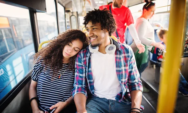 坐在公交车上的年轻快乐男人和女人 — 图库照片