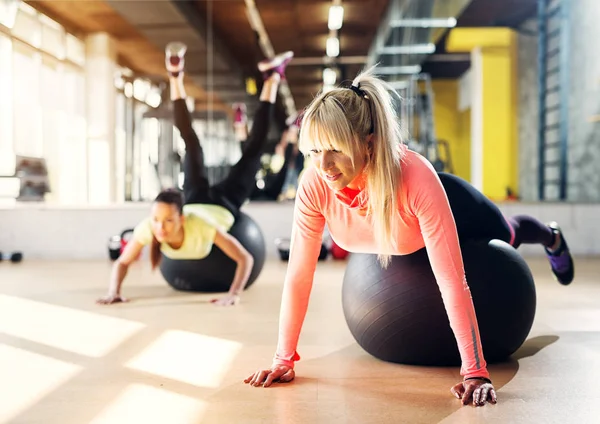 Dos Chicas Jóvenes Enfocadas Gimnasio Usando Bolas Pilates Para Estirarse — Foto de Stock