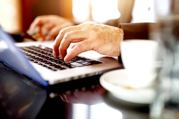 Closeup of male hands on laptop keyboard