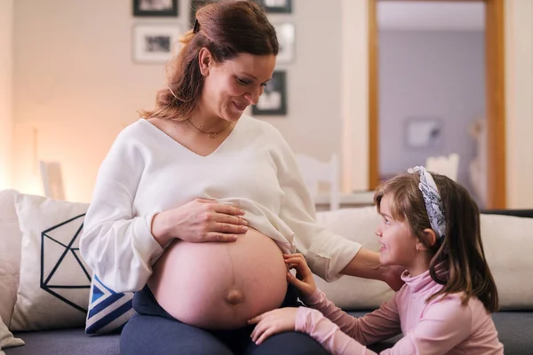 妊娠中の母親と一緒に幸せな幼児の女の子 — ストック写真
