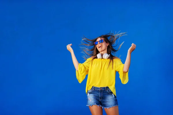 Cheerful Girl Yellow Shirt Standing Blue Wall Headset Her Neck — Stock Photo, Image