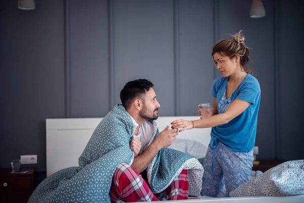 Zorgvuldige Jonge Vrouw Medicijnen Zieke Vriend Bed — Stockfoto