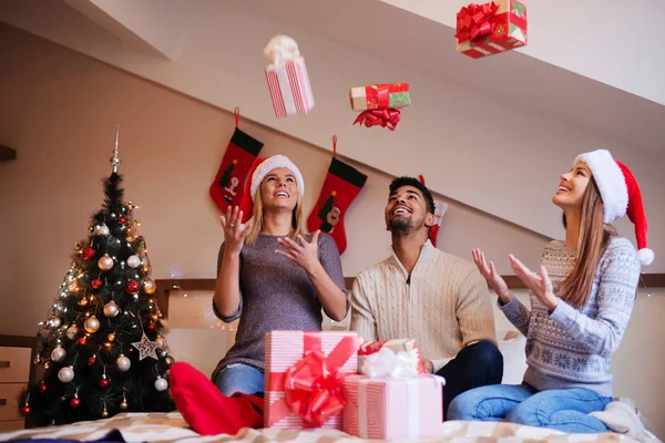 Glada vänner dekorera julgran — Stockfoto