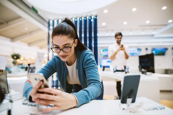 Hermosa Chica Moderna Está Probando Nuevo Teléfono Tienda Tecnología Mientras — Foto de Stock