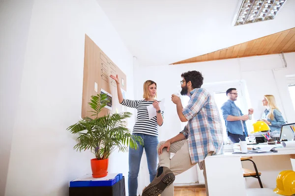 group of four young successful business people having break in office