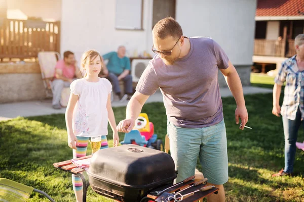 cheerful family cooking with outdoor grill at backyard, happy family barbecue