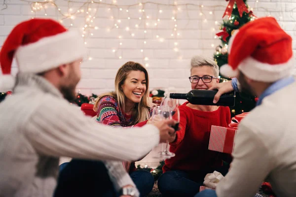 若い幸せな家庭でクリスマスを祝うパーティー 使い捨てからすにワインを注ぐ — ストック写真