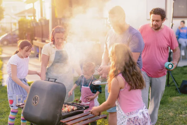 阳光明媚的日子 在后院用户外烤架烹调欢乐的家庭 — 图库照片