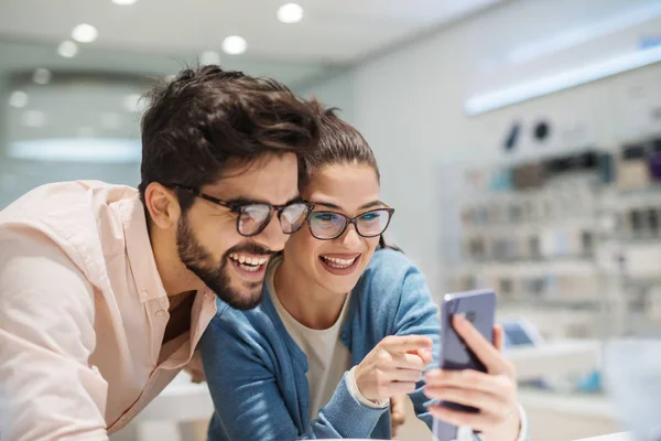 Belo Casal Sorrindo Testando Alguns Telefones Loja Eletrônica Sorrindo Olhar — Fotografia de Stock