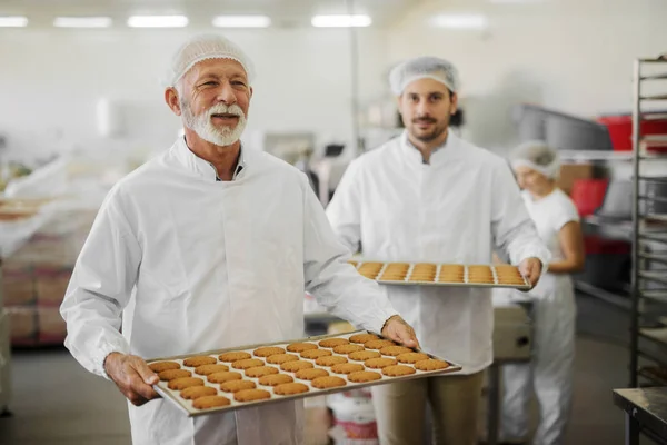 Imagem Dois Funcionários Fábrica Alimentos Masculinos Roupas Estéreis Segurando Bandejas — Fotografia de Stock