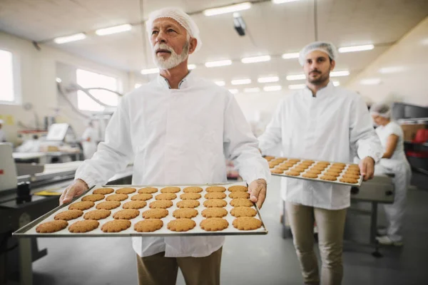 Imagem Dois Funcionários Fábrica Alimentos Masculinos Roupas Estéreis Segurando Bandejas — Fotografia de Stock