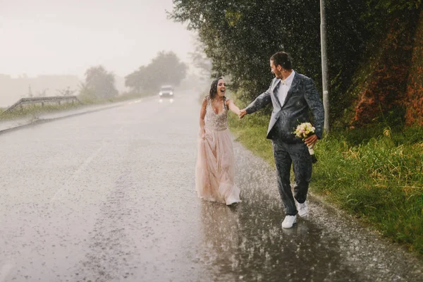 Μόλις Παντρεμένο Ζευγάρι Κρατώντας Χέρια Και Περπάτημα Στη Βροχή Περπάτημα — Φωτογραφία Αρχείου
