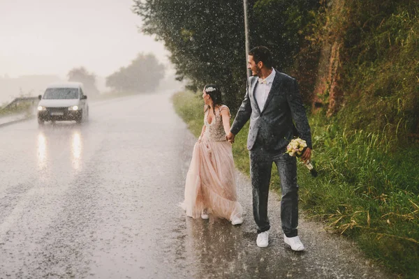 Полностью Мокрая Супружеская Пара Идущая Дождём Дороге Наблюдая Проезжающими Машинами — стоковое фото