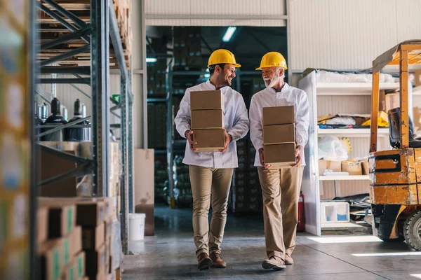 Imagen Dos Trabajadores Almacenes Con Cascos Cabeza Llevando Cajas Las — Foto de Stock