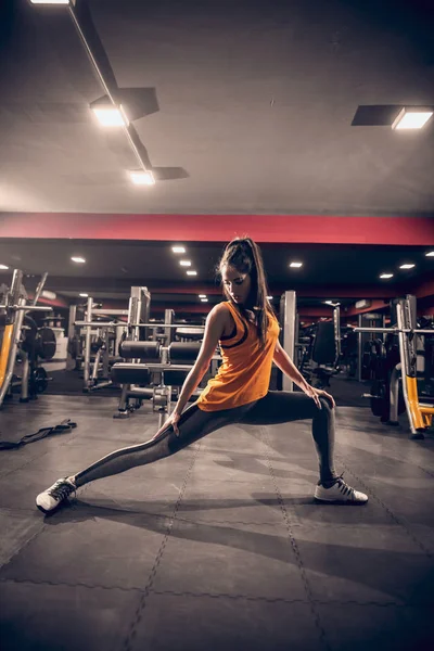 Välformade Kvinna Stretching Innan Övningar Bakgrunden Träningsutrustning — Stockfoto