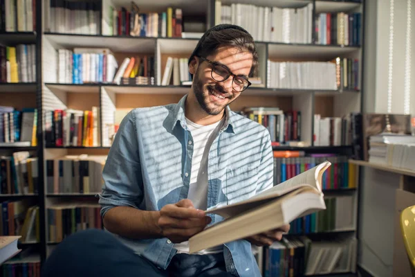 Retrato Del Joven Estudiante Sonriente Leyendo Libro Biblioteca —  Fotos de Stock