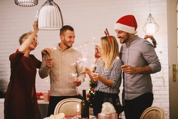 Amigos Felizes Comemorando Natal Casa Com Faíscas Luzes Bengala — Fotografia de Stock