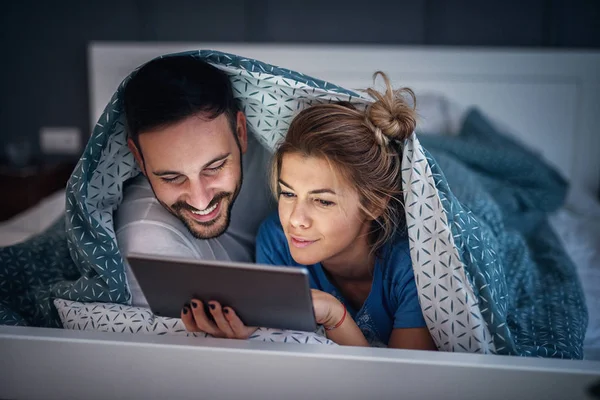 Adorável Jovem Casal Relaxado Deitado Sob Cobertor Seu Mau Lendo — Fotografia de Stock