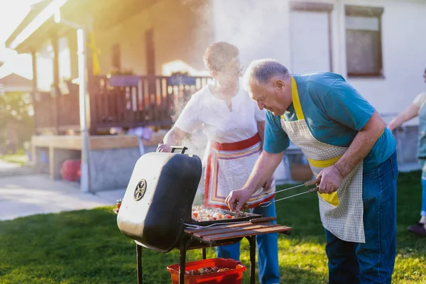 Arka Bahçede Barbekü Yapma Büyük Çift Aile Ile Vakit Geçirmek — Stok fotoğraf