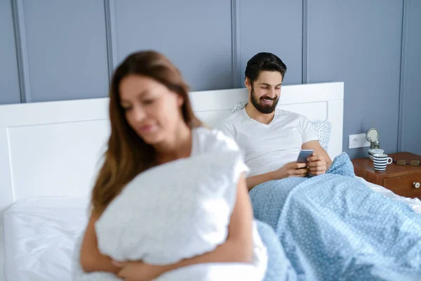 Yatakta Erkek Arka Plan Üzerinde Elinde Tablet Ile Oturan Genç — Stok fotoğraf
