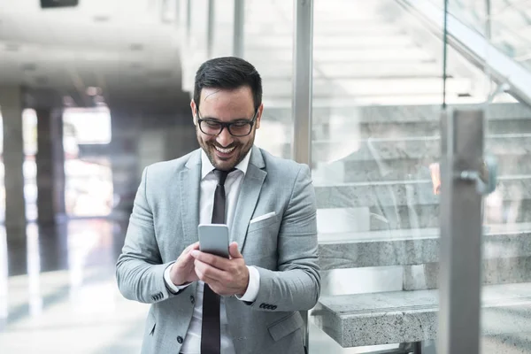 Felice Giovane Uomo Affari Utilizzando Smart Phone Sms Mentre Appoggia — Foto Stock