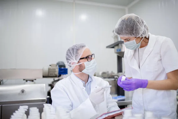 Tecnólogo Segurando Resultados Testes Seu Assistente Segurando Produto Cosmético — Fotografia de Stock