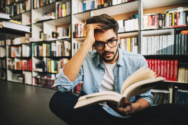 Retrato Jovem Estudante Pensativo Lendo Livro Biblioteca — Fotografia de Stock