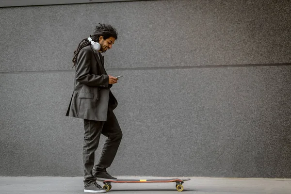 Przystojny Młody Skater Stylowe Dredami Korzystanie Smartfona Ulicy — Zdjęcie stockowe