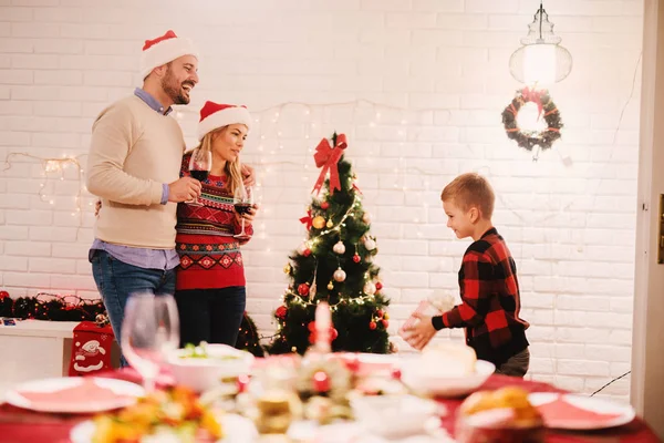 Ευτυχισμένη Οικογένεια Γιορτάζει Χριστούγεννα Στο Σπίτι Γονείς Πίνοντας Κρασί Κοντά — Φωτογραφία Αρχείου