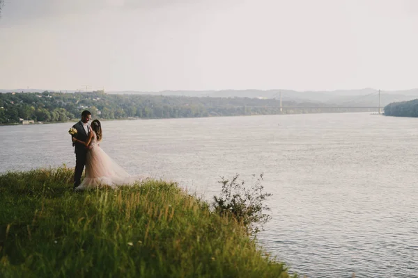 Emotional Picture Just Married Couple Standing Field Kissing River Background — Stock Photo, Image