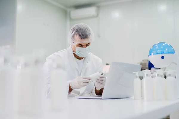 Picture Young Man Sterile Clothes Sitting Bright Laboratory Checking Quality — Stock Photo, Image