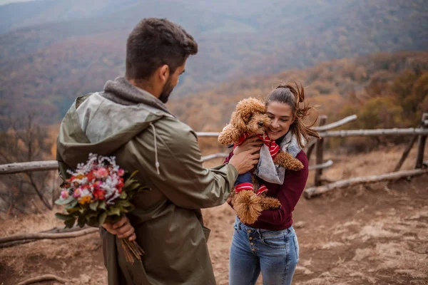 Mujer Sosteniendo Perro Mientras Hombre Pie Delante Ella Escondiendo Flores — Foto de Stock