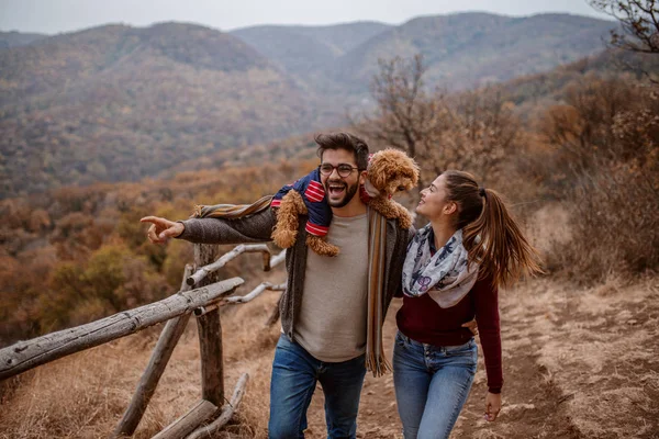 Hombre Abrazando Novia Sosteniendo Perro Sobre Los Hombros Mientras Camina — Foto de Stock