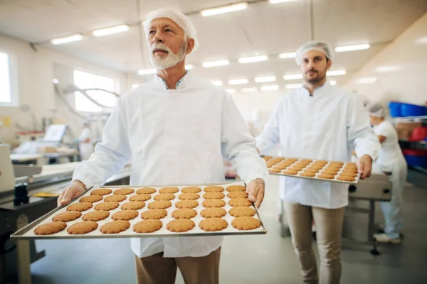 Dois Homens Carregando Biscoitos Pratos Fábrica Alimentos — Fotografia de Stock