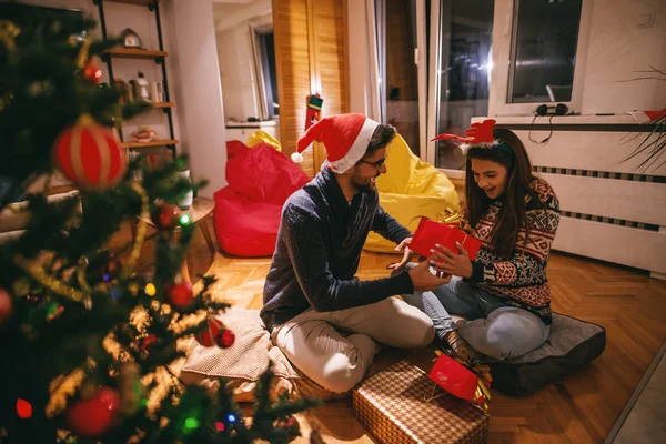 Ζευγάρι Ανταλλάσσοντας Δώρα Χριστουγέννων Ενώ Κάθεται Στο Πάτωμα Πρώτο Πλάνο — Φωτογραφία Αρχείου