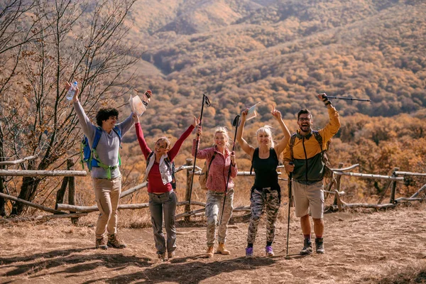 Hikers Standing Glade Arms Raised Looking Camera Background Forest Autumn — Stock Photo, Image