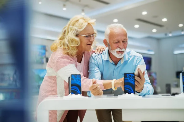 Pareja Mayor Eligiendo Teléfono Inteligente Tech Tienda Interior —  Fotos de Stock