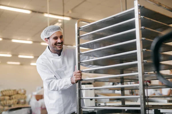 Junger Kaukasier Schiebt Leere Teller Auf Regal Lebensmittelfabrik — Stockfoto