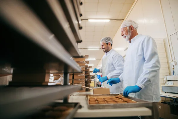 Εργαζόμενοι Συσκευασία Cookies Στα Πλαίσια Ενώ Στέκεται Εργοστάσιο Τροφίμων — Φωτογραφία Αρχείου