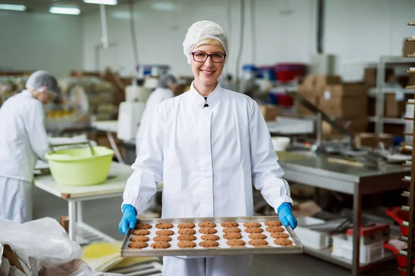 Jovem Trabalhador Feminino Feliz Segurando Biscoitos Recém Assados Folha Flandres — Fotografia de Stock