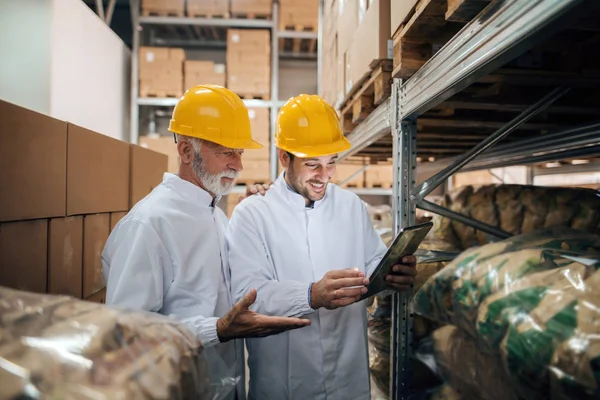 Zwei Mitarbeiter Unterhalten Sich Und Lächeln Während Sie Lager Stehen — Stockfoto