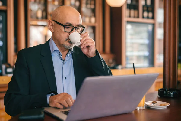 Empresario Mayor Barbudo Traje Usando Portátil Beber Café Mientras Está —  Fotos de Stock