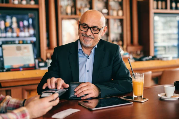 Reifer Fröhlicher Geschäftsmann Mit Tablet Und Bezahlscheck Mit Kreditkarte Café — Stockfoto