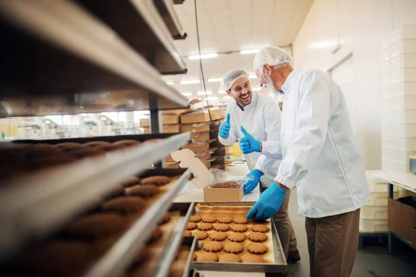 食品工場に立ちながらボックスにクッキーを梱包の労働者 — ストック写真