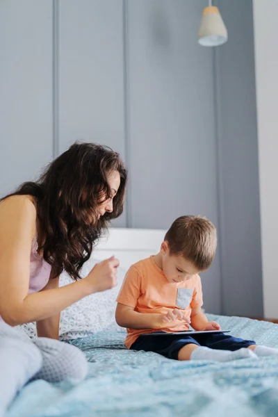 Pequeno Garoto Assistindo Desenhos Animados Tablet Enquanto Sentado Cama Enquanto — Fotografia de Stock