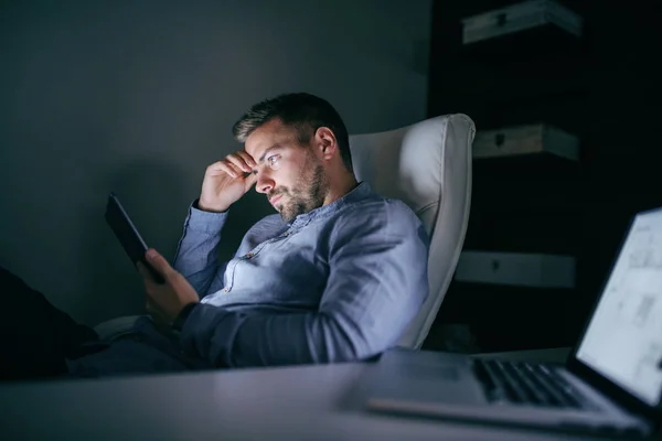 Gece Geç Saatte Ofiste Oturan Tablet Kullanarak Sıkılmış Çalışan Yan — Stok fotoğraf