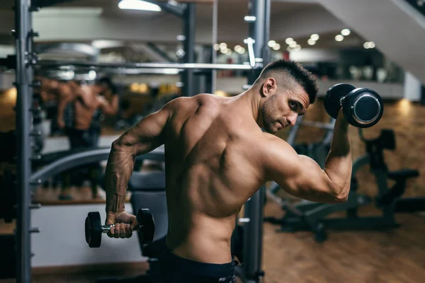Stark Muskulös Man Poserar Med Hantlar Ett Gym Sidovy — Stockfoto