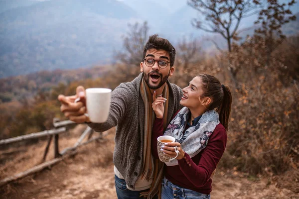 Casal Com Canecas Nas Mãos Homem Apontar Para Alguma Coisa — Fotografia de Stock