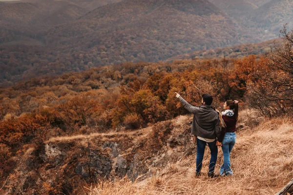 Pareja Cogida Mano Disfrutando Naturaleza Hombre Apuntando Montaña Respaldos Girados — Foto de Stock